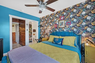a bedroom with a blue bed with a colorful wall at The Extraordinary Camino Hotel in Camino