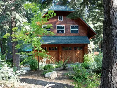 a wooden house in the middle of some trees at Traditional Log Cabin Rental for Couples on the West Shore of Lake Tahoe, California in Tahoe City
