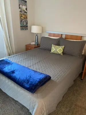 a large bed with a blue blanket on top of it at Captivating Riverfront Vacation Rental for Large Groups in Three Rivers, California in Three Rivers