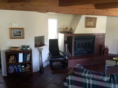 a living room with a fireplace and a chair at Captivating Riverfront Vacation Rental for Large Groups in Three Rivers, California in Three Rivers