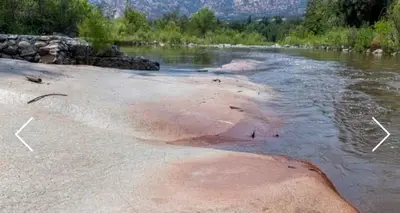 a river with a rock in the water at Captivating Riverfront Vacation Rental for Large Groups in Three Rivers, California in Three Rivers