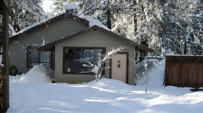 a house with snow on the ground in front of it at Country Cabin with Spa Hot Tub and Private Deck near Rollins Lake in California in Gold Run