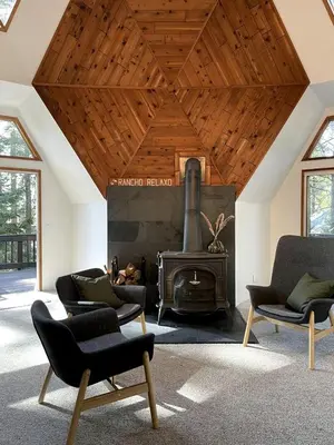 a living room with a fireplace and chairs and a stove at Secluded Dome Rental Surrounded by Stunning Nature near Arnold, California in Arnold