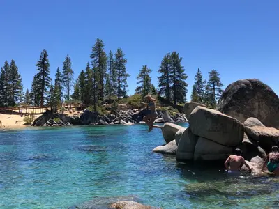 a group of people jumping off rocks into a river at First level studio Unit #7 close to everything bike, ski, swim Zephyr Cove! in Zephyr Cove
