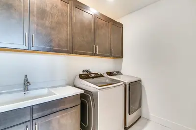 a small kitchen with a washer and a sink at Pool Paradise Spacious Tracy Home with Yard! in Tracy