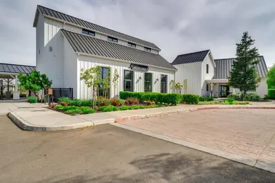 a large white building with a parking lot at Pool Paradise Spacious Tracy Home with Yard! in Tracy