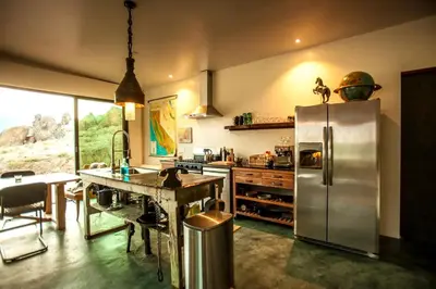 a kitchen with a stainless steel refrigerator and a table at Amazing Lone Pine Cabin for Glamping in California in Lone Pine