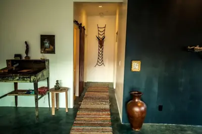 a hallway with a table and a vase on the wall at Amazing Lone Pine Cabin for Glamping in California in Lone Pine