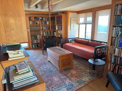 a living room with a couch and some books at Priest Ranch with Guest House and Pool in Big Oak Flat