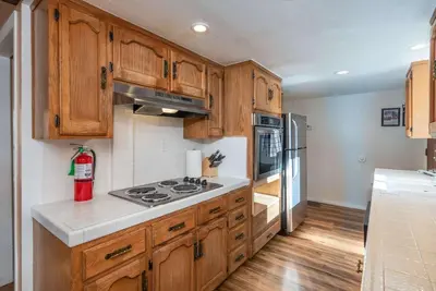 a kitchen with wooden cabinets and a stove at Yosemite Aviary - Bird's Eye View Awesome Upper Unit in Yosemite West