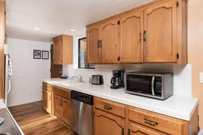 a kitchen with wooden cabinets and a microwave at Yosemite Aviary - Bird's Eye View Awesome Upper Unit in Yosemite West