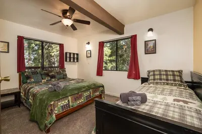 a bedroom with two beds and a ceiling fan at Yosemite Aviary and Quail Within Yosemite - 2 Separate Family Units Welcoming Up To 14 Guests in Yosemite West