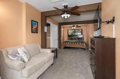 a living room with a couch and a flat screen tv at Yosemite Aviary and Quail Within Yosemite - 2 Separate Family Units Welcoming Up To 14 Guests in Yosemite West