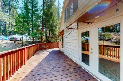 a wooden walkway leading to a porch on a house at CC Cabin - Full Game Room & Wrap Around Deck in Shaver Lake