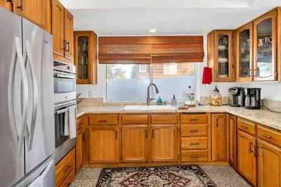 a kitchen with wooden cabinets and a sink at CC Cabin - Full Game Room & Wrap Around Deck in Shaver Lake