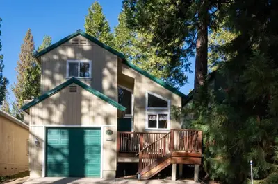 a house with a green garage and trees at A Tuscan Adventure in California 3 BDR Sleeps 8 in Shaver Lake