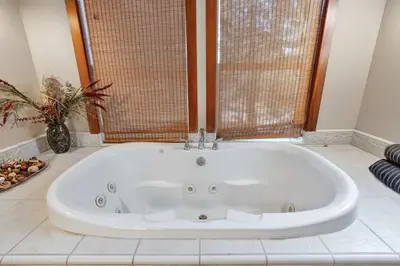 a large white tub in a bathroom with a window at Gorgeous 5 BDR Traviloli Mountain Retreat for 10 in Shaver Lake