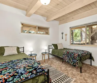 a bedroom with two beds and a window at Cavu Cabin - A Classic Mountainside Escape in Shaver Lake