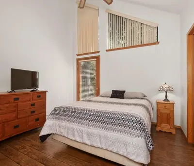 a bedroom with a bed and a flat screen tv at Granite View Lodge - Minutes from Water in Shaver Lake