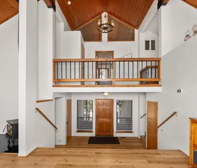 an open living room with a staircase and a wooden door at Granite View Lodge - Minutes from Water in Shaver Lake