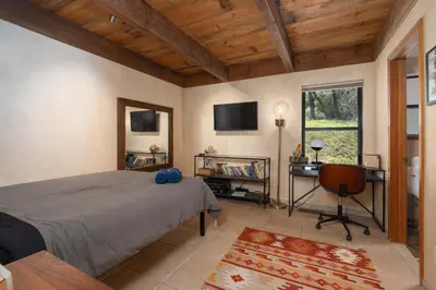 a bedroom with a bed and a desk and a television at Happy Days Retreat with Private Pool in Bass Lake Annex