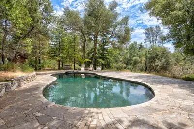 a swimming pool in the middle of a patio at Happy Days Retreat with Private Pool in Bass Lake Annex
