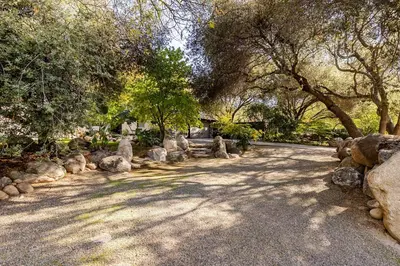 a road with trees and rocks in a park at River Magic - Riverfront Family Fun & Lux Design in Three Rivers