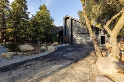 a house with a large glass door in a yard at River Soul – Riverfront Luxury & Stunning Views in Three Rivers