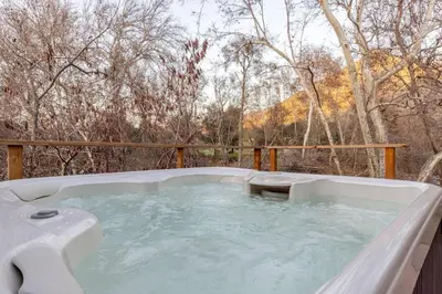 a hot tub on a deck with trees in the background at Sequoia Arquitectural Wonder with Hot Tub & Views in Three Rivers