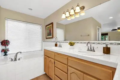 a bathroom with two sinks and a tub and a mirror at Awesome Views Game Room Hot Tub and More in Oakhurst
