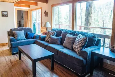 a living room with a blue couch and two tables at Red House - Minutes to Shaver Lake in Shaver Lake
