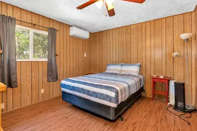 a bedroom with a bed and a ceiling fan at Immersed in Nature Manzanita Cabin with Hot Tub in Oakhurst