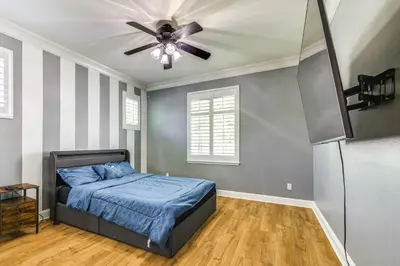 a bedroom with a bed and a ceiling fan at 5 Mi to Dtwn Modesto Family Home with Patio! in Modesto