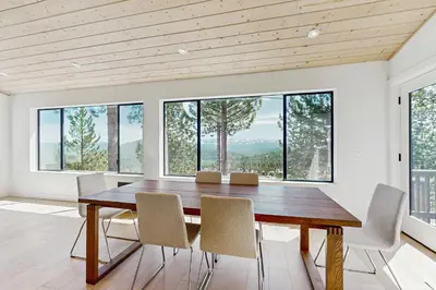 a dining room with a table and chairs and windows at Paradise on Pinnacle in Truckee