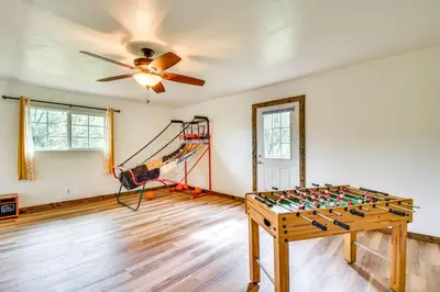 a living room with a ceiling fan and a table at Sierra Serenity Scenic Mtn Escape with Game Room in Oakhurst