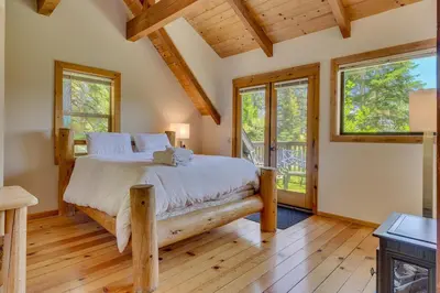 a bedroom with a bed in a room with windows at Hyphen 4-bedrooms rental, private beach, filtered view in Tahoe City