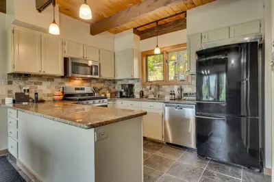 a kitchen with white cabinets and a black refrigerator at Hyphen 4-bedrooms rental, private beach, filtered view in Tahoe City