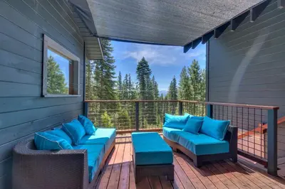a deck with blue cushions and chairs on a balcony at Hyphen 5-bedrooms rental, private beach, filtered view in Tahoe City