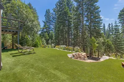 a yard with a garden with a bench in the grass at Hyphen 5-bedrooms rental, private beach, filtered view in Tahoe City