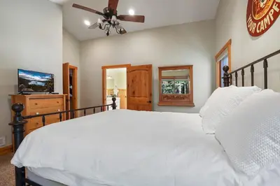 a bedroom with a white bed and a ceiling fan at WSH1030 - Camp Westwater home in Tahoma