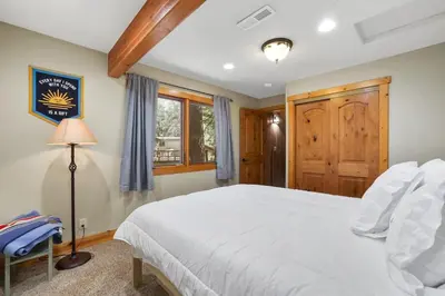 a bedroom with a white bed and a wooden door at WSH1030 - Camp Westwater home in Tahoma