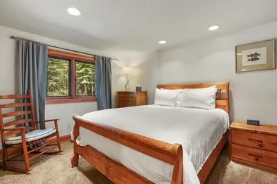 a bedroom with a large bed and a chair at WSH1030 - Camp Westwater home in Tahoma