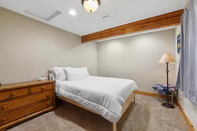 a bedroom with a bed and a dresser and a lamp at WSH1030 - Camp Westwater home in Tahoma