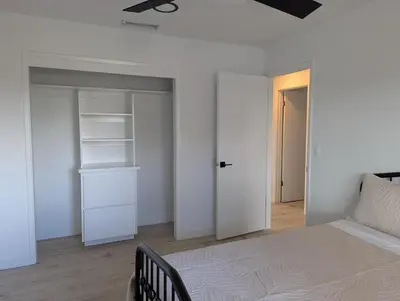 a white bedroom with a bed and a closet at Welcome to Lilith's House! in Clovis