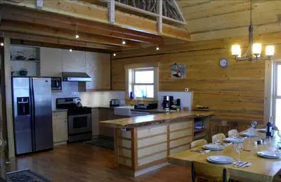 a kitchen with wooden walls and a refrigerator and a table at Updated Winter Getaway Great for Skiing in Soda Springs, California in Soda Springs