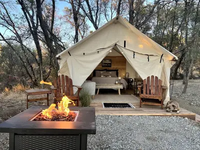 a tent with a table and a fire pit at Secluded Safari Tent Situated in Rural Western El Dorado County Overlooking Majestic Folsom Lake, Northern California in Pilot Hill