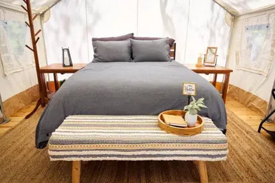 a bedroom with a bed and a table with a tray at Secluded Safari Tent Situated in Rural Western El Dorado County Overlooking Majestic Folsom Lake, Northern California in Pilot Hill