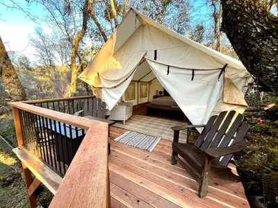 a tent with a hammock and a chair on a deck at Secluded Safari Tent Situated in Rural Western El Dorado County Overlooking Majestic Folsom Lake, Northern California in Pilot Hill
