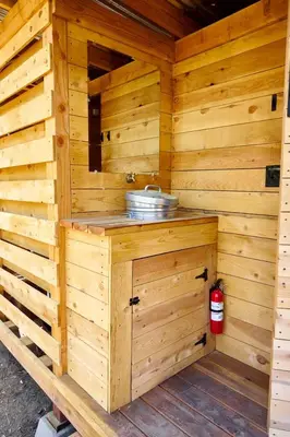 a wooden sauna with a sink and a fire extinguisher at Safari Tents for Romantic Escapes in California's El Dorado County in Pilot Hill