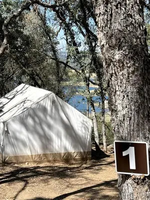 a white tent with a sign next to a tree at Safari Tents for Romantic Escapes in California's El Dorado County in Pilot Hill